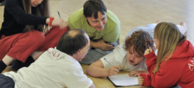 Anjali workshop, dancers in studio crowding around notebook